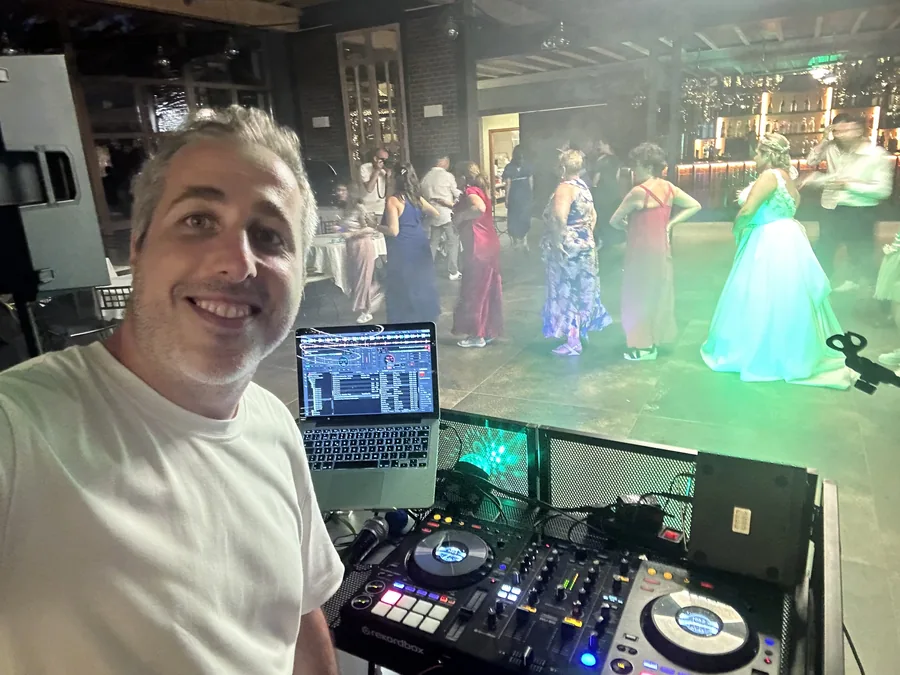 DJ Ponte pinchando en boda de noche — invitados bailando en terraza