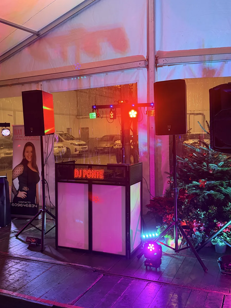Setup DJ Ponte iluminado con cartel de neón en evento de empresa navideño en carpa