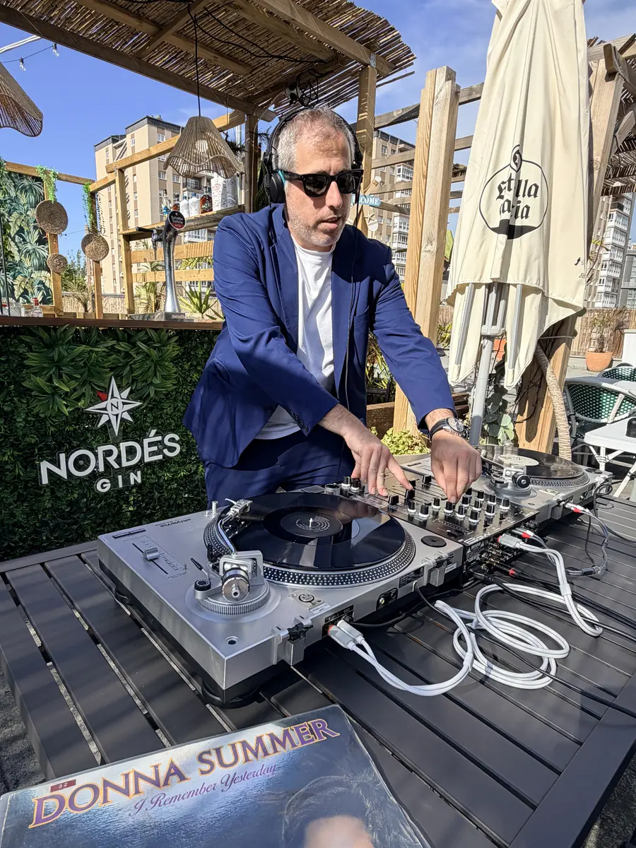 DJ Ponte mezclando en los platos en terraza exterior